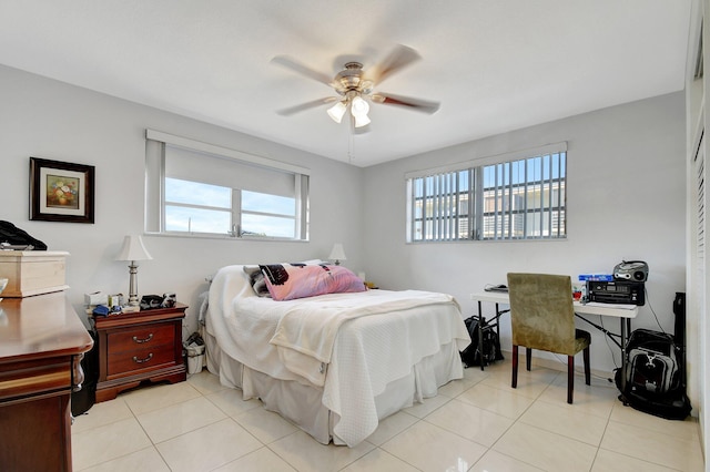 tiled bedroom featuring multiple windows and ceiling fan