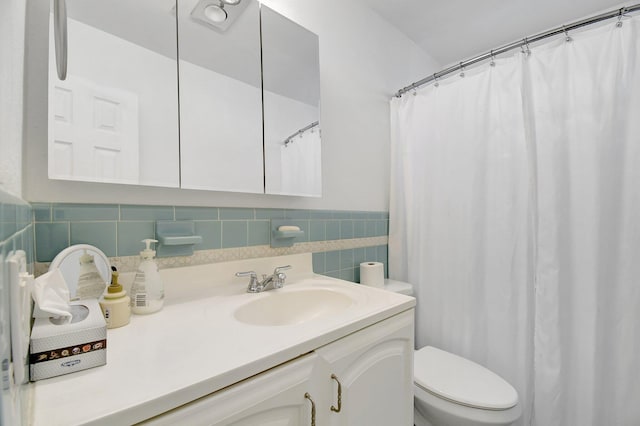 bathroom with vanity, toilet, and backsplash