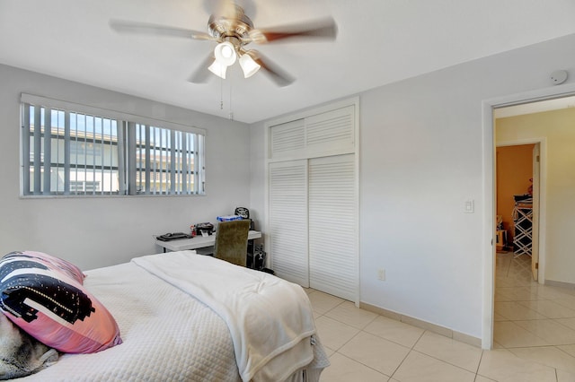 tiled bedroom featuring ceiling fan and a closet