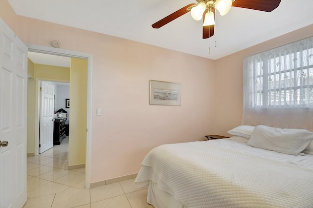 tiled bedroom featuring ceiling fan