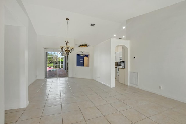 empty room featuring a notable chandelier, high vaulted ceiling, and light tile patterned floors