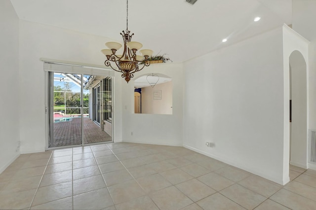 empty room featuring light tile patterned flooring and a notable chandelier