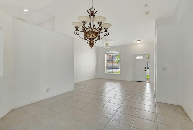 tiled spare room with a chandelier