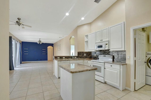 kitchen featuring a kitchen island, white cabinets, white appliances, and kitchen peninsula