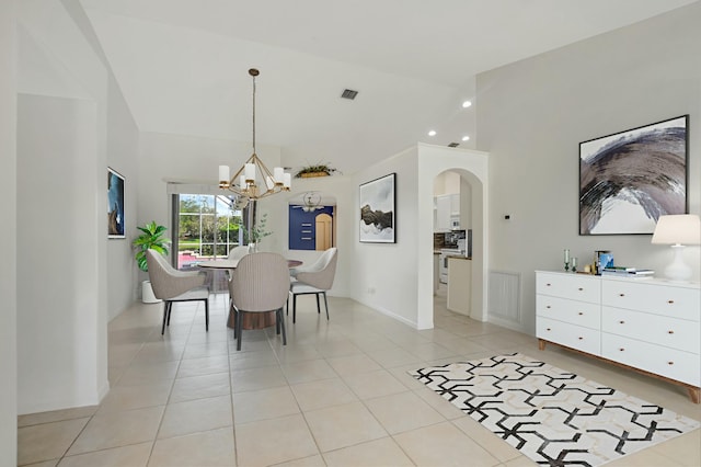 tiled dining space featuring lofted ceiling and a chandelier