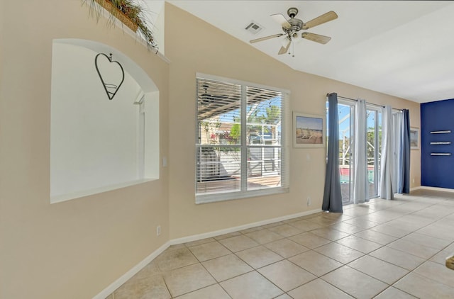 spare room featuring lofted ceiling, light tile patterned floors, and ceiling fan