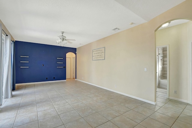 unfurnished room with light tile patterned flooring, a textured ceiling, and ceiling fan