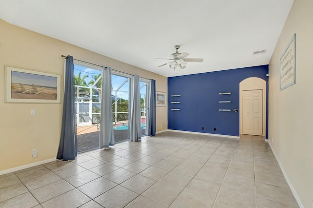 tiled empty room featuring ceiling fan