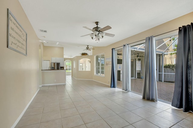 spare room featuring light tile patterned floors, a wealth of natural light, and ceiling fan