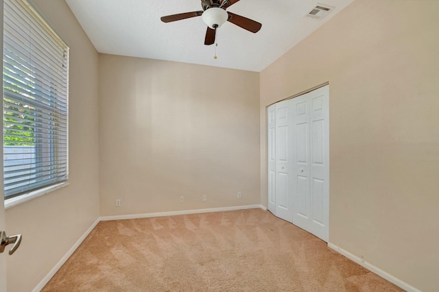 unfurnished bedroom featuring light carpet, ceiling fan, and a closet