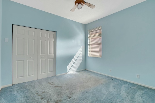 unfurnished bedroom featuring ceiling fan, a closet, and light carpet