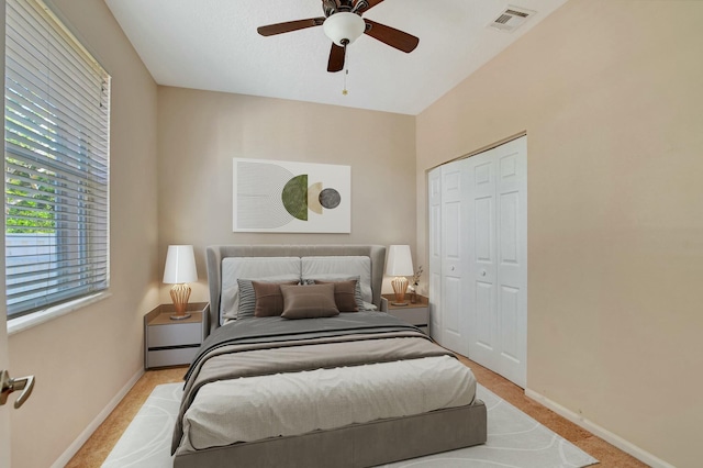 carpeted bedroom with ceiling fan and a closet