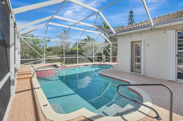 view of pool featuring a patio area, glass enclosure, and an in ground hot tub