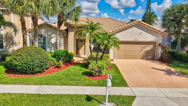 mediterranean / spanish-style house featuring a garage and a front lawn