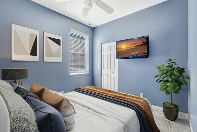 carpeted bedroom featuring ceiling fan and a closet