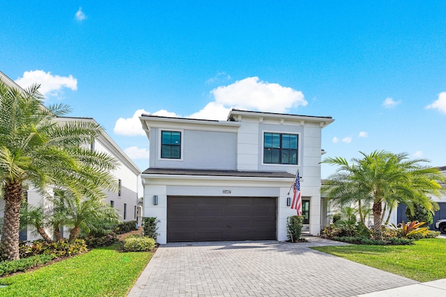 view of front of property featuring a garage and a front lawn