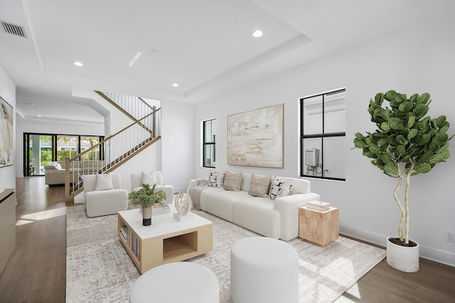 living room featuring hardwood / wood-style floors and a tray ceiling