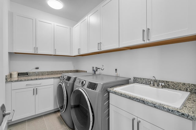 laundry area featuring cabinets, separate washer and dryer, sink, and light tile patterned floors