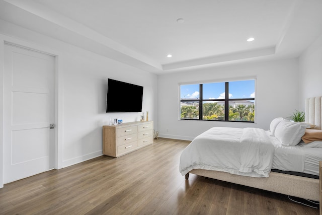 bedroom featuring a tray ceiling and hardwood / wood-style flooring