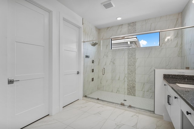 bathroom with a shower with door and vanity