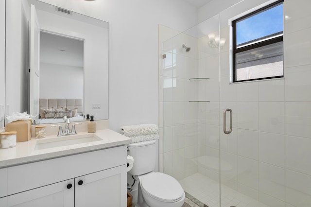 bathroom with vanity, a shower with shower door, and toilet