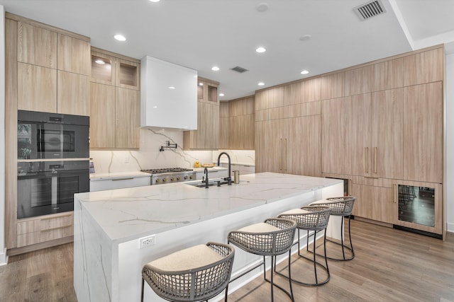 kitchen with a breakfast bar, a large island, and light stone countertops