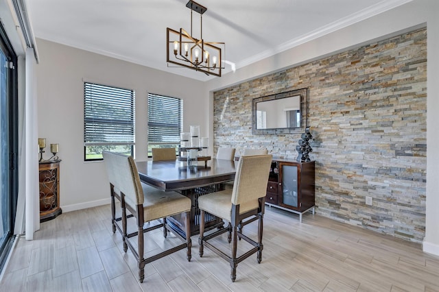 dining space with crown molding and an inviting chandelier