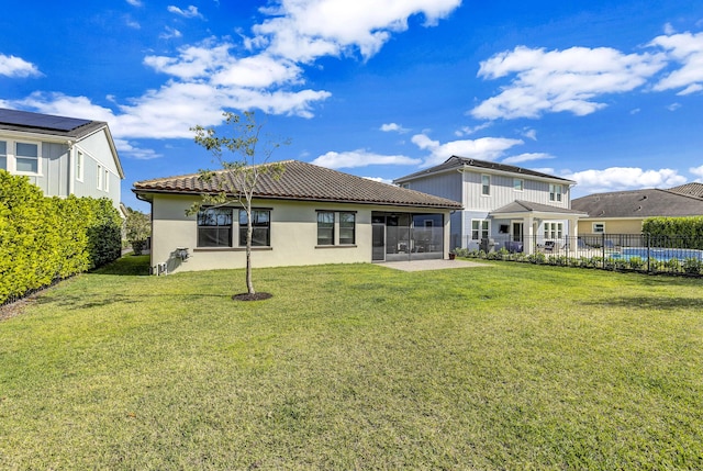 back of property featuring a patio, a sunroom, and a lawn