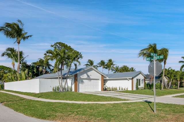 ranch-style house featuring a garage and a front yard