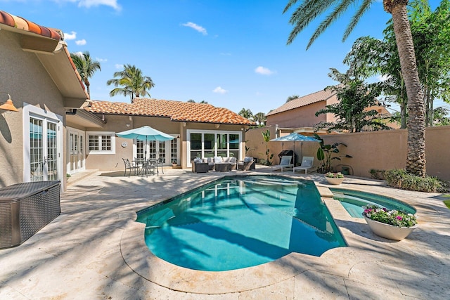 view of swimming pool with french doors, outdoor lounge area, and a patio