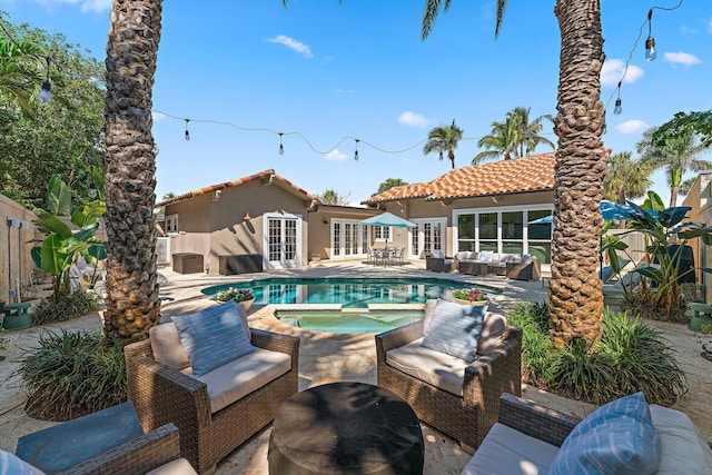 view of swimming pool with a patio area, an outdoor hangout area, french doors, and an in ground hot tub