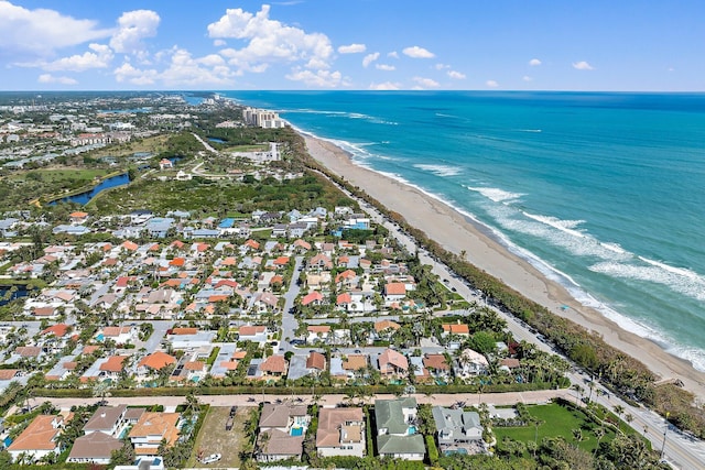 birds eye view of property featuring a water view and a beach view