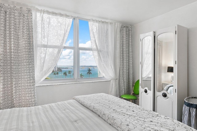 bedroom featuring multiple windows and a water view