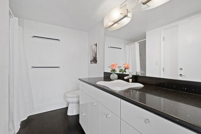 bathroom with wood-type flooring, toilet, and vanity