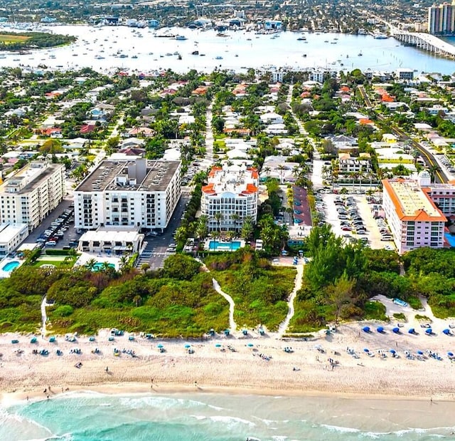 birds eye view of property featuring a beach view and a water view