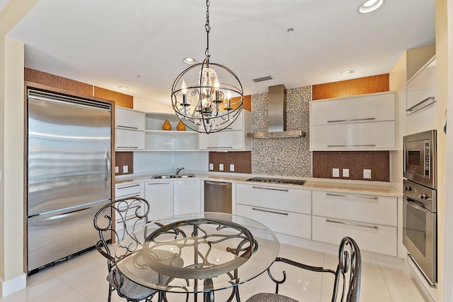 155 Ocean Ave Unit 603, Palm Beach Shores, FL 33404 - kitchen featuring built in appliances, wall chimney exhaust hood, a sink, modern cabinets, and a chandelier
