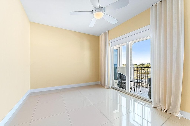 tiled spare room with baseboards and ceiling fan