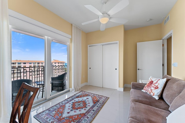 living room with visible vents, baseboards, and ceiling fan