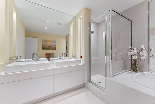 bathroom with double vanity, tile patterned floors, a shower stall, a bath, and visible vents