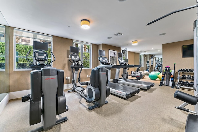 workout area featuring recessed lighting, carpet, visible vents, and a healthy amount of sunlight