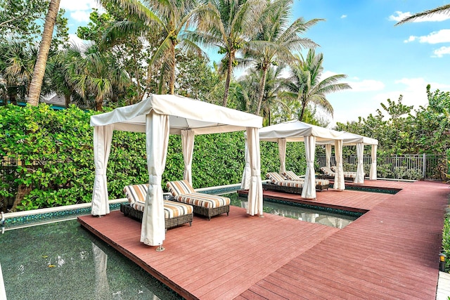 dock area with a deck, a gazebo, and fence