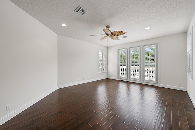 unfurnished room featuring baseboards, dark wood finished floors, visible vents, and a ceiling fan