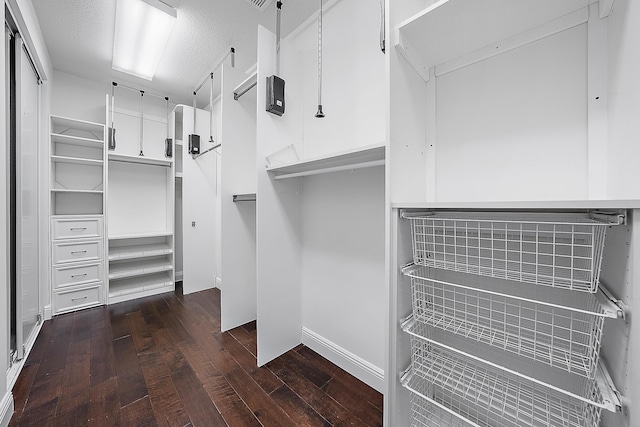 spacious closet with dark wood finished floors