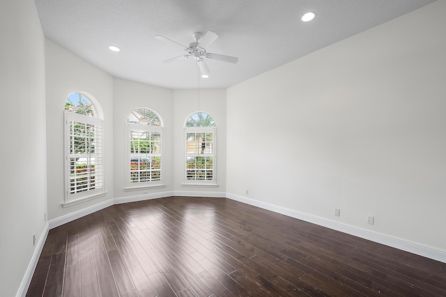 unfurnished room featuring a ceiling fan, baseboards, dark wood finished floors, and a textured ceiling