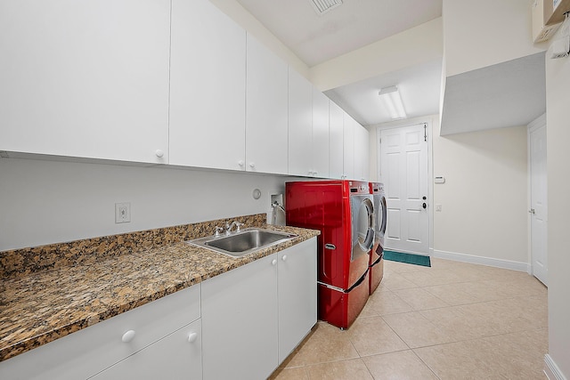 laundry room with cabinet space, light tile patterned floors, baseboards, washer and clothes dryer, and a sink