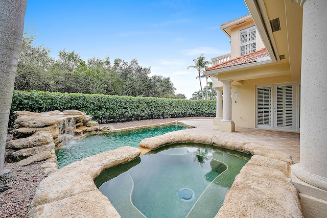 view of pool featuring an in ground hot tub