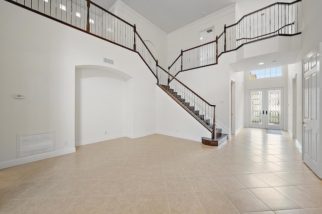 foyer featuring stairs, french doors, ornamental molding, and visible vents