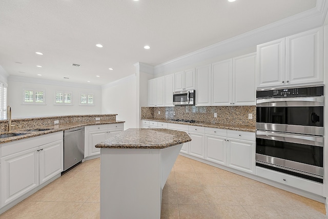 kitchen featuring a sink, stainless steel appliances, a kitchen island, and white cabinets