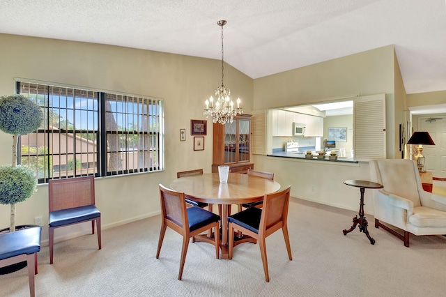 dining room featuring light colored carpet, a chandelier, vaulted ceiling, and a textured ceiling