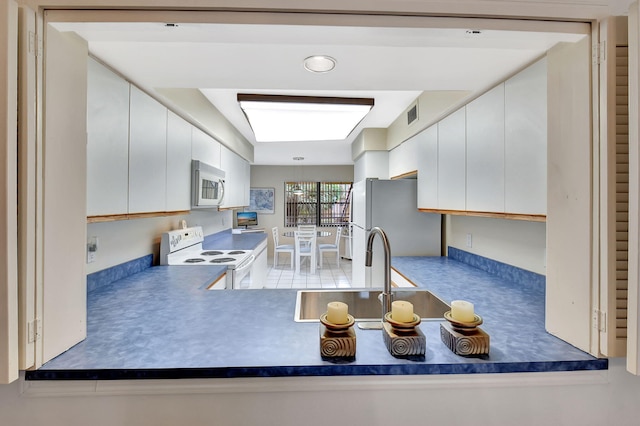 kitchen featuring sink, white appliances, and white cabinets